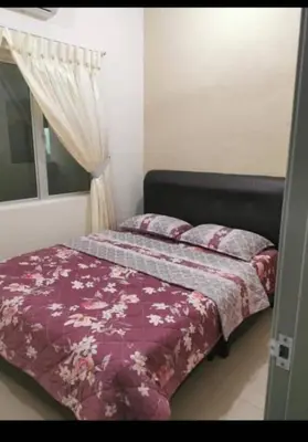 a bedroom with a bed with a purple comforter and a window at DhiyaAdraHomestay in Chemor