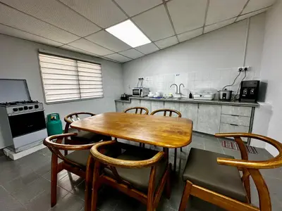 a kitchen with a wooden table and some chairs at Molek Vacation Home in Gelugor