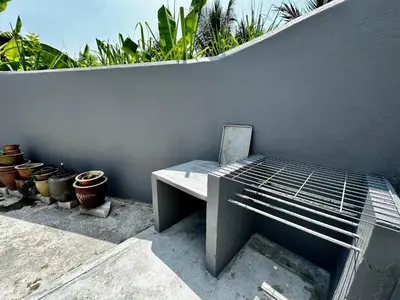 a bench sitting next to a wall with potted plants at Molek Vacation Home in Gelugor