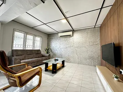 a living room with a couch and a tv at Molek Vacation Home in Gelugor