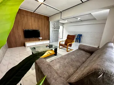 a living room with a couch and a tv at Molek Vacation Home in Gelugor