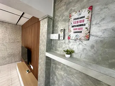 a bathroom with a television and a painting on the wall at Molek Vacation Home in Gelugor