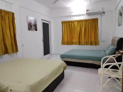 a room with two beds and a chair in it at Gurney PENstay in George Town