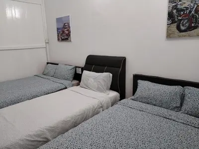 a bedroom with two beds and a motorcycle on the wall at Gurney PENstay in George Town