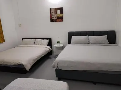a bedroom with two beds and a table at Gurney PENstay in George Town