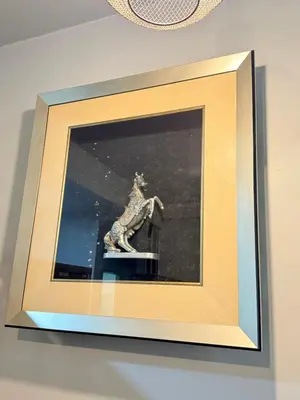 a picture of a statue in a frame on a wall at AYAAN Flora Quintet Apartment & Fifa Home 4 with Free Parking in Tanah Rata