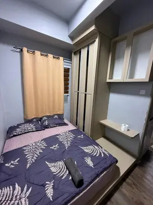 a bedroom with a bed with a purple comforter and a window at AYAAN Flora Quintet Apartment & Fifa Home 4 with Free Parking in Tanah Rata