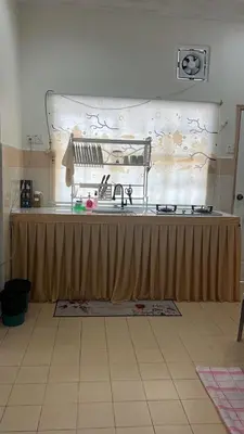 a kitchen with a table with a counter top at Puterihomestay in Gua Sai