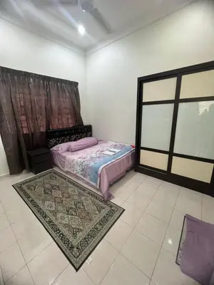 a bedroom with a bed and a rug and a window at Puterihomestay in Gua Sai