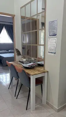 a dining room table with two chairs and a mirror at Puterihomestay in Gua Sai