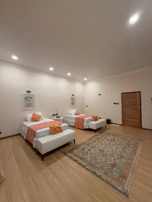 two beds in a large room with a rug at The Marina View in Gua Sai