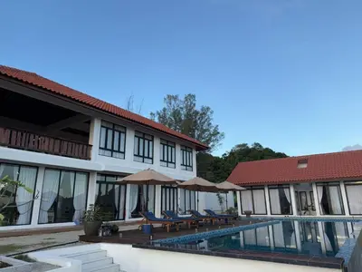 a resort with a pool and chairs and umbrellas at The Marina View in Gua Sai