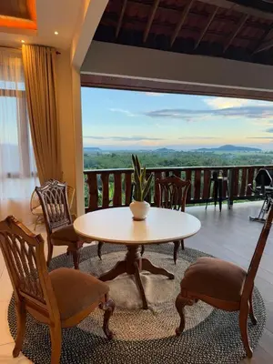 a table and chairs in a room with a balcony at The Marina View in Gua Sai