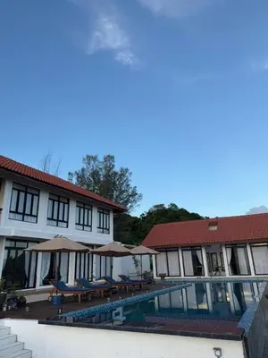 a resort with a swimming pool and chairs and umbrellas at The Marina View in Gua Sai