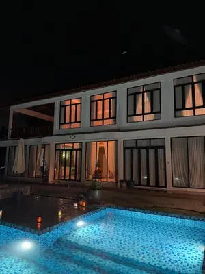 a swimming pool in front of a house at night at The Marina View in Gua Sai