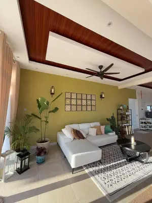 a living room with a white couch and a ceiling fan at The Marina View in Gua Sai