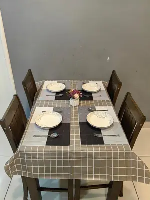 a table with chairs and plates on top of it at Warmth Nest4U Homestay Butterworth in Butterworth