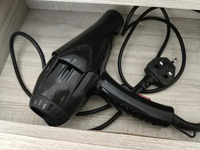a black blow dryer sitting on top of a table at Warmth Nest4U Homestay Butterworth in Butterworth