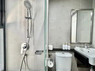 a bathroom with a shower and a toilet and a sink at Tropicana 218 Macalister #softcreamy #InfinityPool #7pax #3BR2bath #Quality well maintained #Private host in George Town