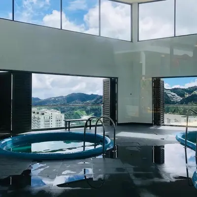 a swimming pool in a building with a large window at Vika Homestay in Brinchang