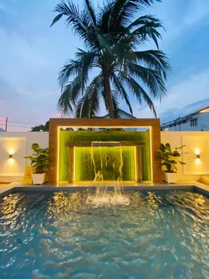 a fountain in the middle of a pool with a palm tree at LYL Ipoh Garden Private Pool Villa-18pax 5BR in Ipoh