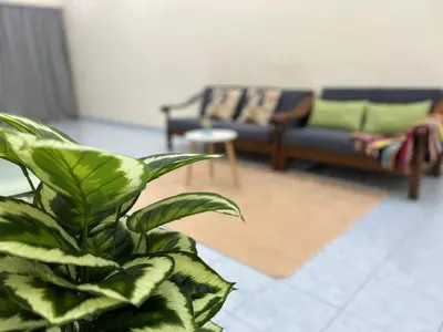 a woman sitting on a couch in a living room at S Home Ipoh in Ipoh