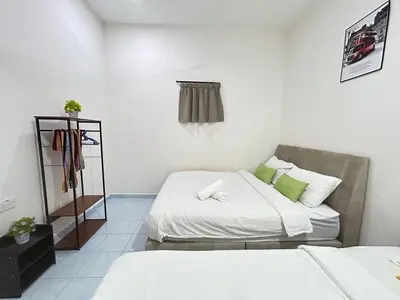 a room with two beds and a shelf with towels at S Home Ipoh in Ipoh