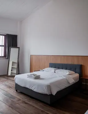 a bedroom with a large bed with a wooden headboard at Ah Tong Residence - 3 mins to Kimberley Night Market in George Town