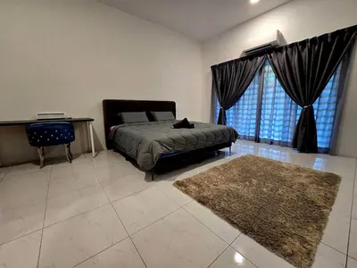 a bedroom with a bed and a table and a rug at The Cozy 88 ipoh & in Ipoh