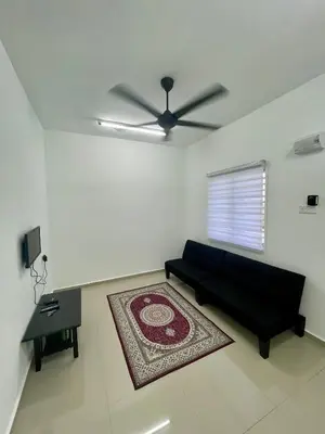 a living room with a black couch and a ceiling fan at Rumah Teduh in Gua Sai