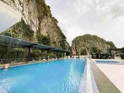 a large swimming pool with a mountain in the background at Small house surrounding with nature in Gua Musang