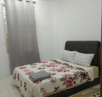 a bedroom with a bed with a flowered blanket at Small house surrounding with nature in Gua Musang