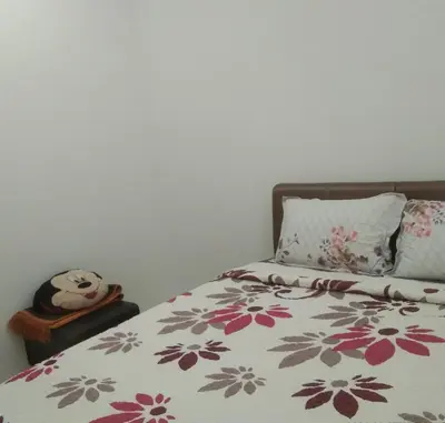 a bedroom with a bed with a floral comforter at Small house surrounding with nature in Gua Musang