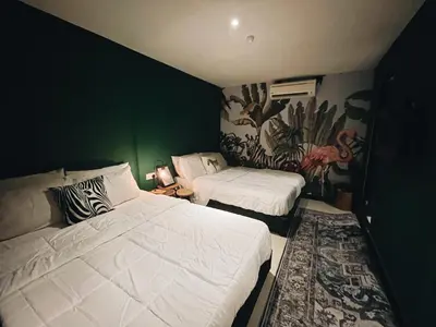 a bedroom with two beds and a green wall at Very Hotel in George Town