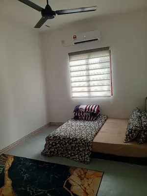a bedroom with a bed in a room with a window at Dhania Homestay in Gua Sai