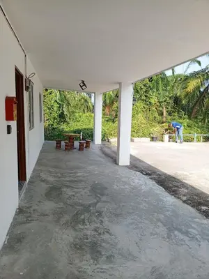 a room with a concrete floor and white walls at Dhania Homestay in Gua Sai