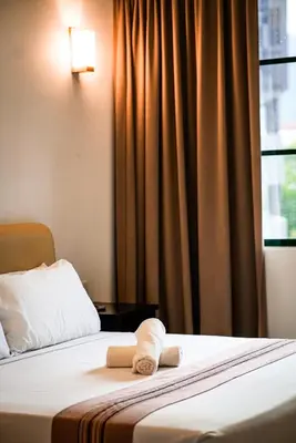 a hotel room with a bed with towels on it at Stallions Suite in Jelutong