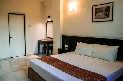 a bedroom with a bed with a desk and a mirror at Stallions Suite in Jelutong