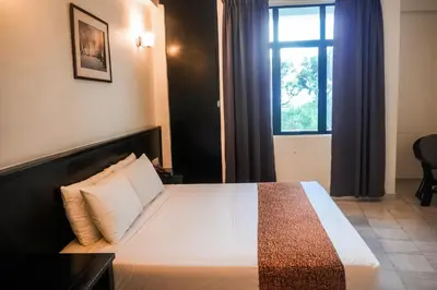 a bedroom with a large bed with a window at Stallions Suite in Jelutong