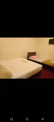 a room with two beds and a table and a chair at Hotel Tropicanna Pulai Point in Ipoh