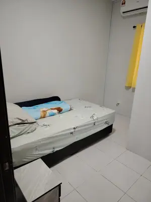 a bed in a room with a white wall at Happy Home in Kuala Kubu Baharu