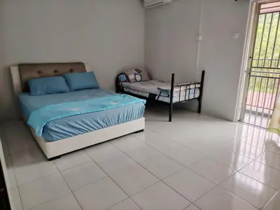 a bedroom with a bed and a chair in it at Happy Home in Kuala Kubu Baharu