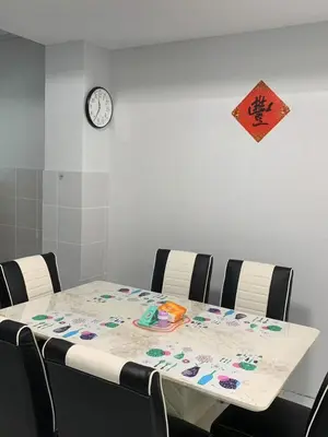 a dining room table with chairs and a clock on the wall at Happy Home in Kuala Kubu Baharu