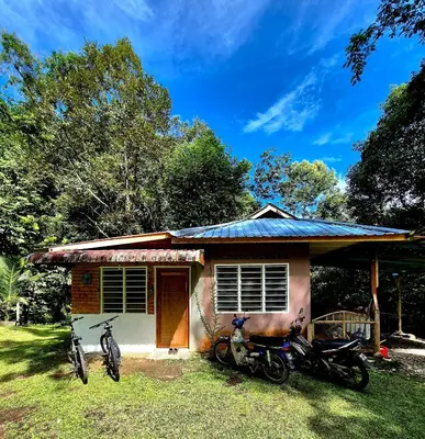 two motorcycles parked in front of a small house at Devalley Basecamp in Kampong Ulu Dong