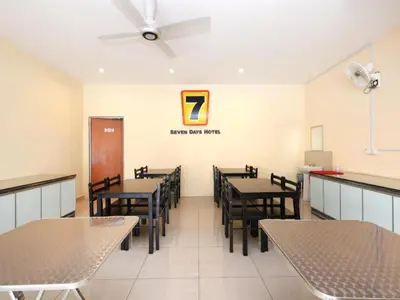 a dining room with tables and chairs and a sign on the wall at Super OYO 635 Seven Days Hotel in Kampong Sempalit Hilir