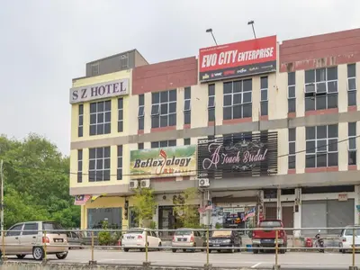 a large building with cars parked in front of it at Sz Hotel in Kampong Tebing Rabak
