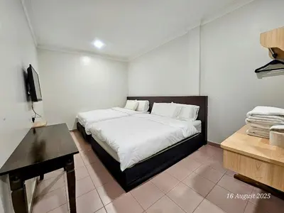 a bedroom with a bed and a desk in it at G Six Hotel in Sitiawan