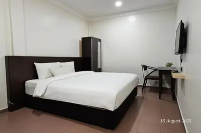 a bedroom with a large bed and a table at G Six Hotel in Sitiawan