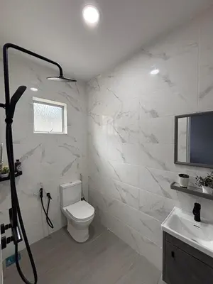 a white bathroom with a toilet and a sink at D'Laman Homestay in Slim River