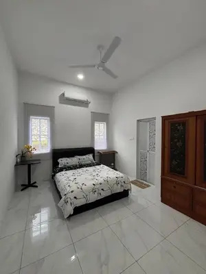 a bedroom with a bed and a dresser in it at D'Laman Homestay in Slim River